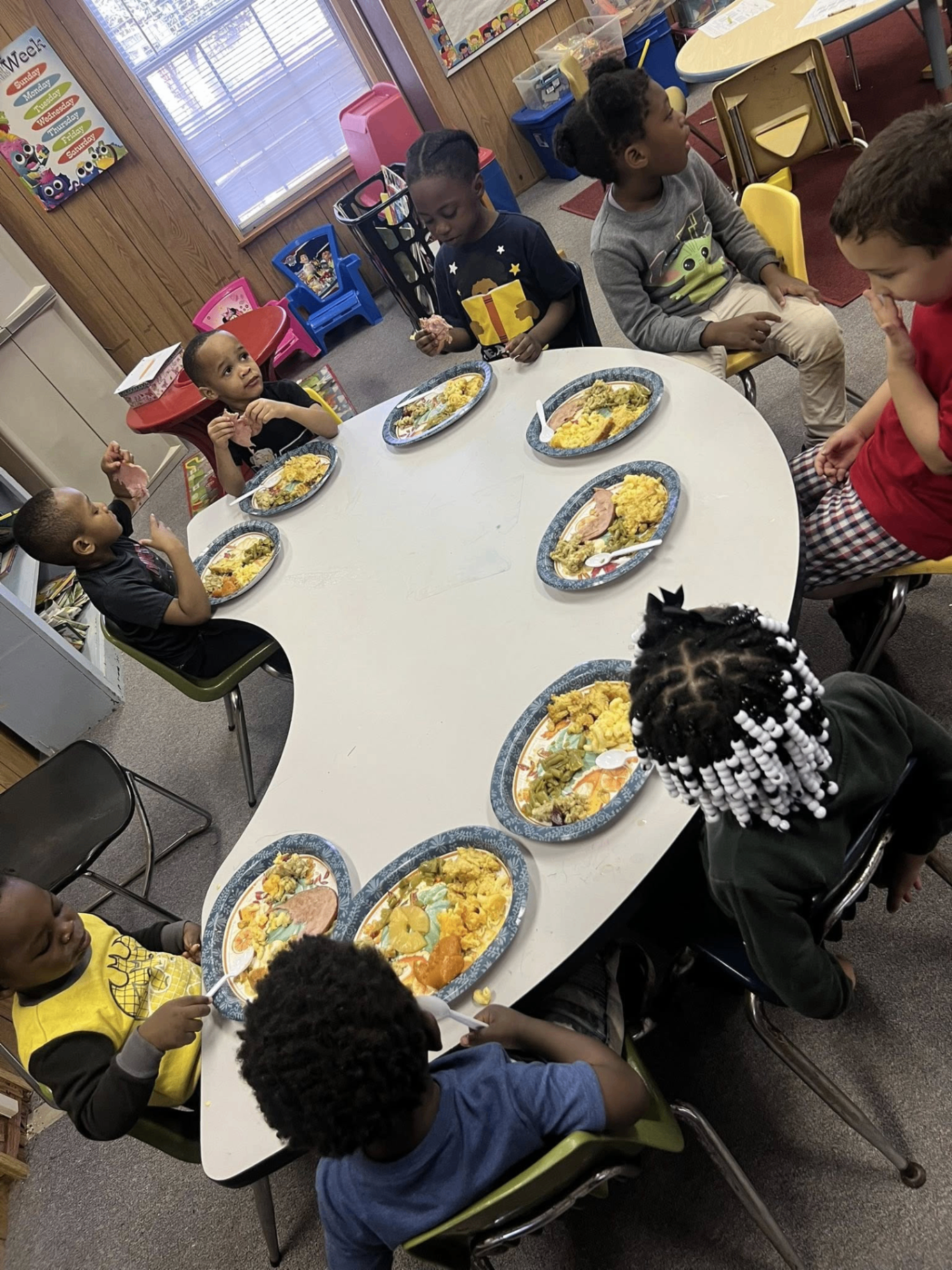 Children enjoying a family-style meal together at the center